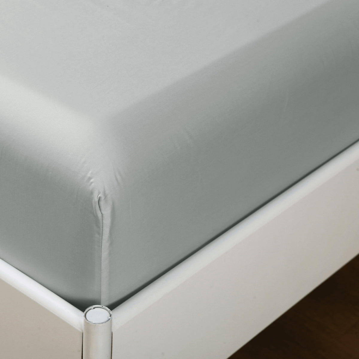 Grey deep pocket fitted sheet fitted over the corner of a thick mattress