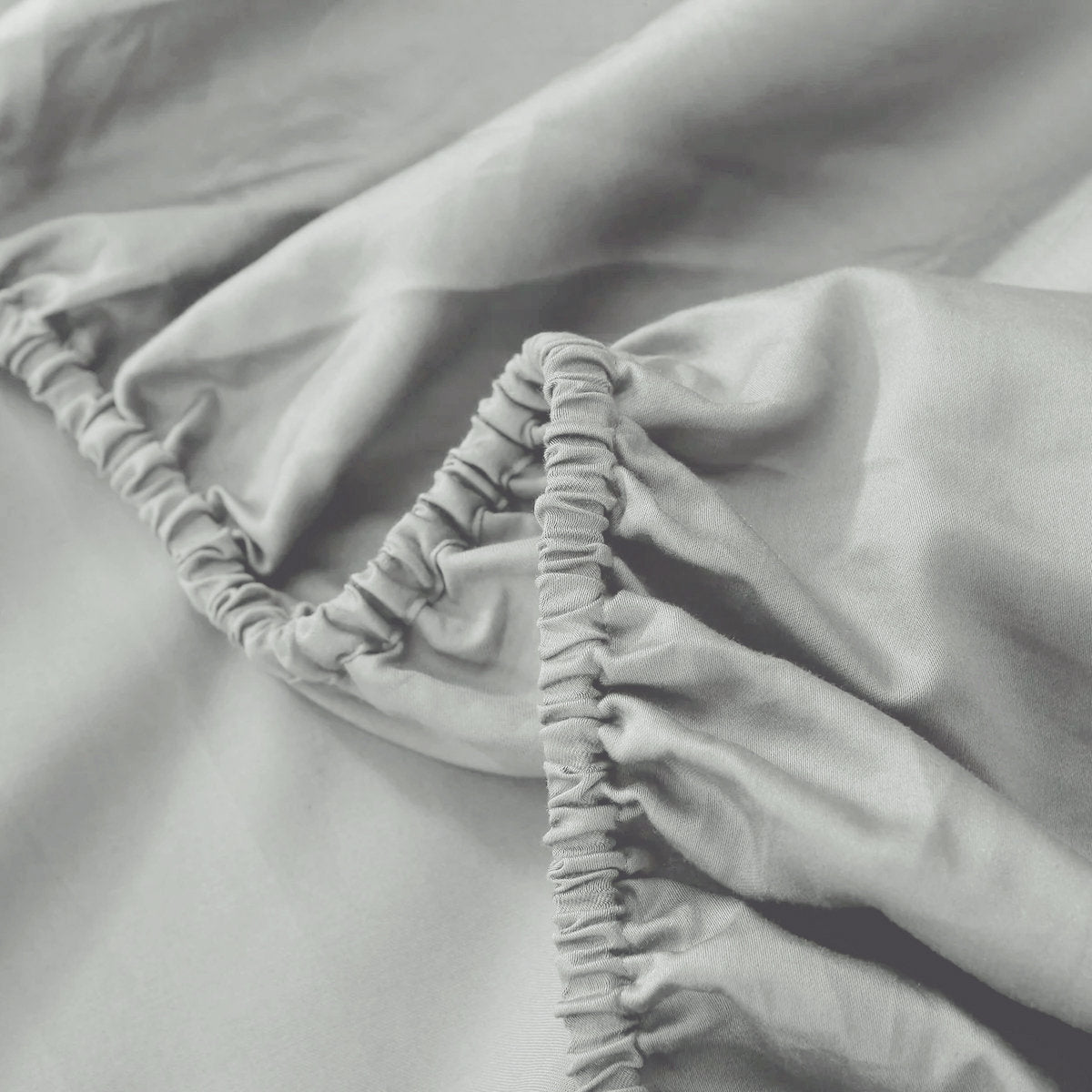 Grey 100% cotton fitted sheet elastic corner close-up